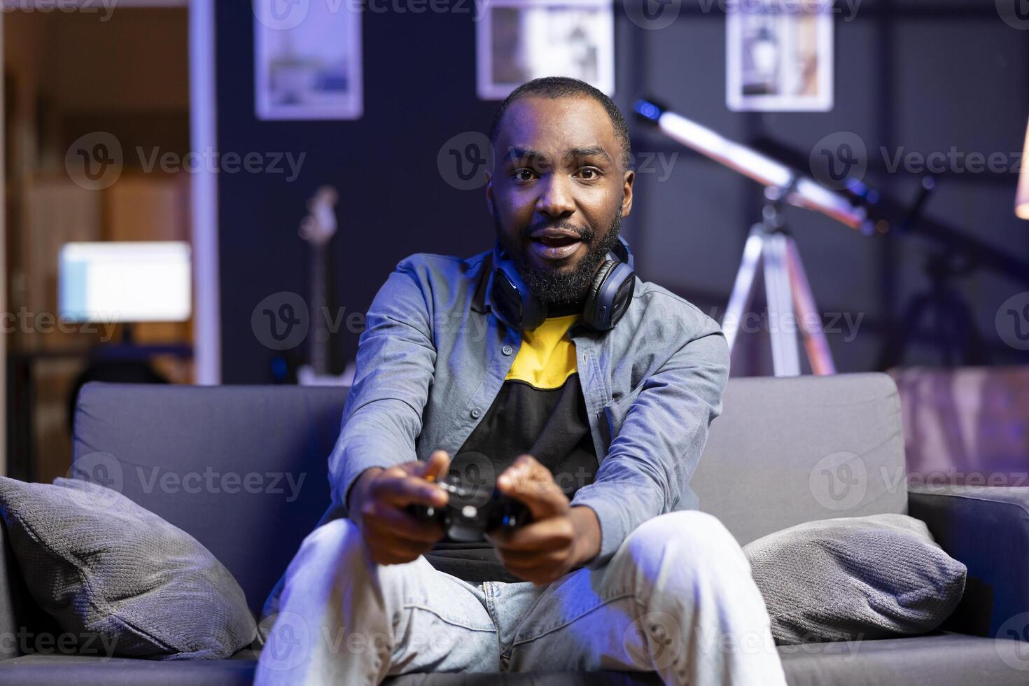Player showing confused face after seeing game over screen, losing singleplayer videogame on console system at home. Portrait of african american man puzzled after being unexpectedly being defeated photo