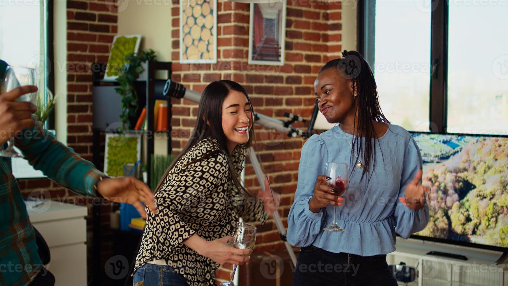 BIPOC group of friends dancing at apartment party, having fun together, shaking their shoulders on rhythm. Multiethnic people doing energetic dance moves, doing funny choreography in living room photo