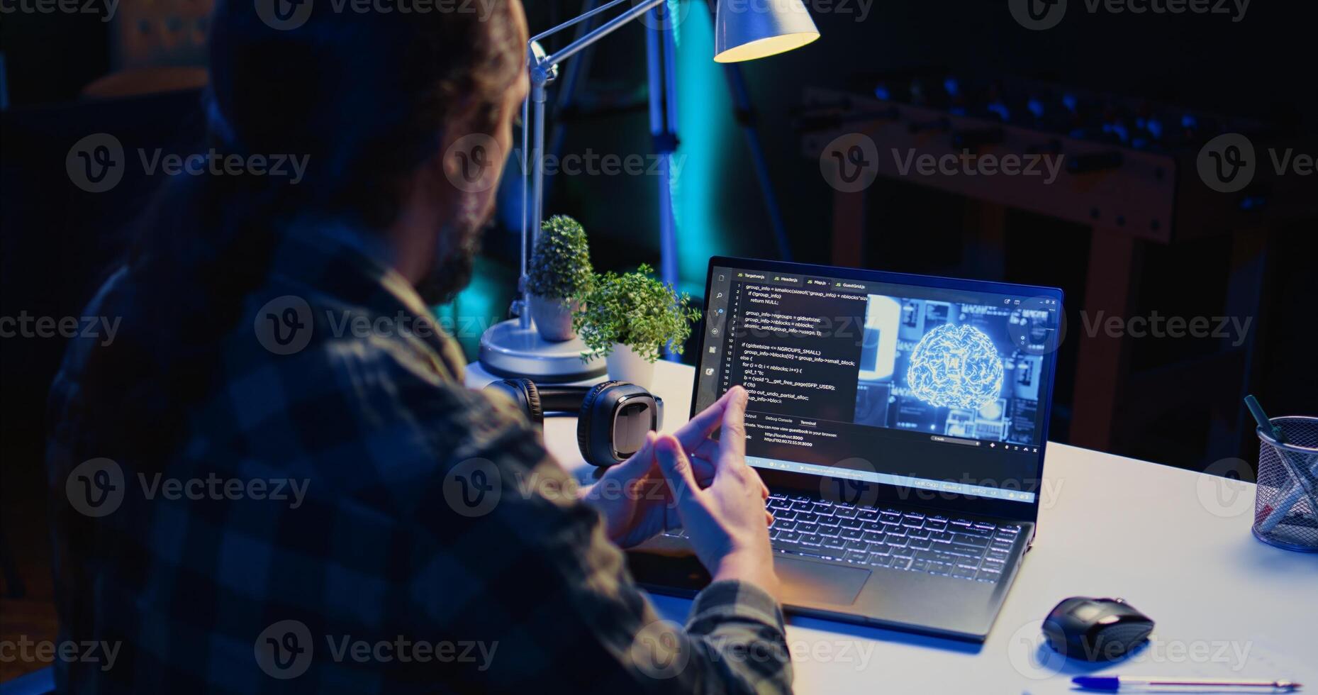Computer scientist updating artificial intelligence machine learning algorithm, writing binary code scripts. Teleworking IT specialist in apartment office uses programming to upgrade AI, camera B photo