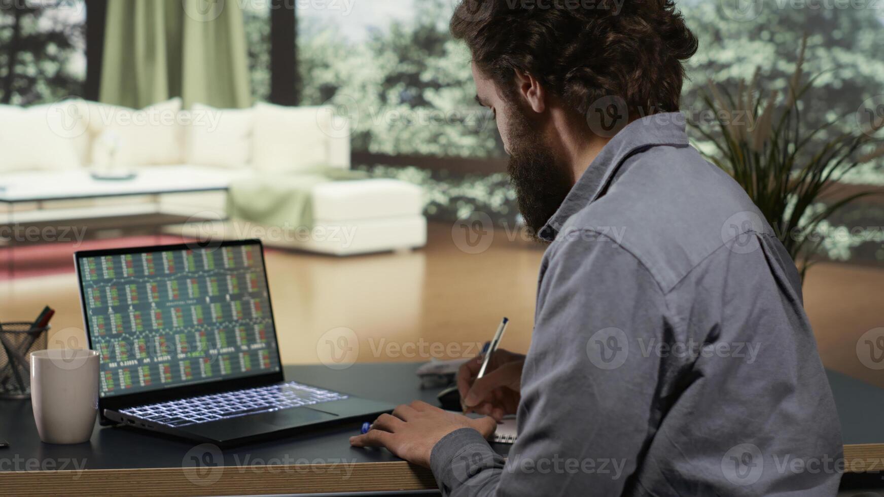 Financial advisor opening laptop to check revenue updates, banking specialist following international trends from his deluxe modern villa in the mountains. Self employed man at his vacation home. photo