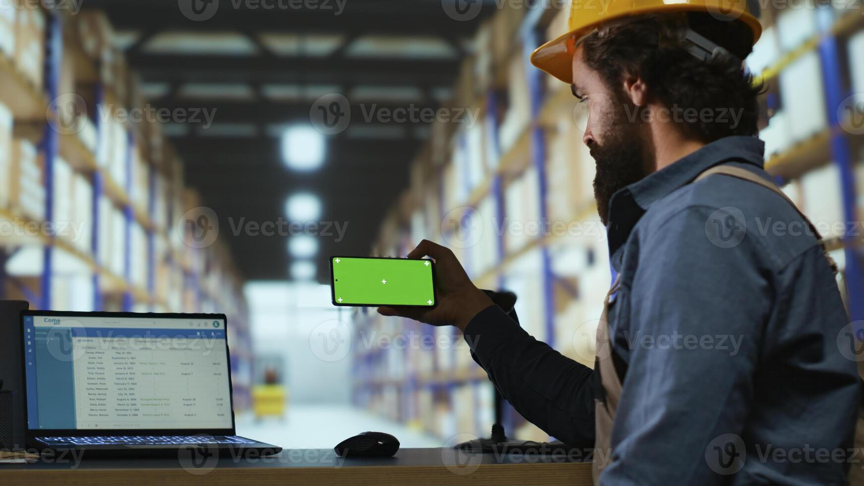 Warehouse manager looks at greenscreen on smartphone display, working on parcel shipment and delivery in industrial depot. Quality control advisor using blank copyspace mockup screen. photo