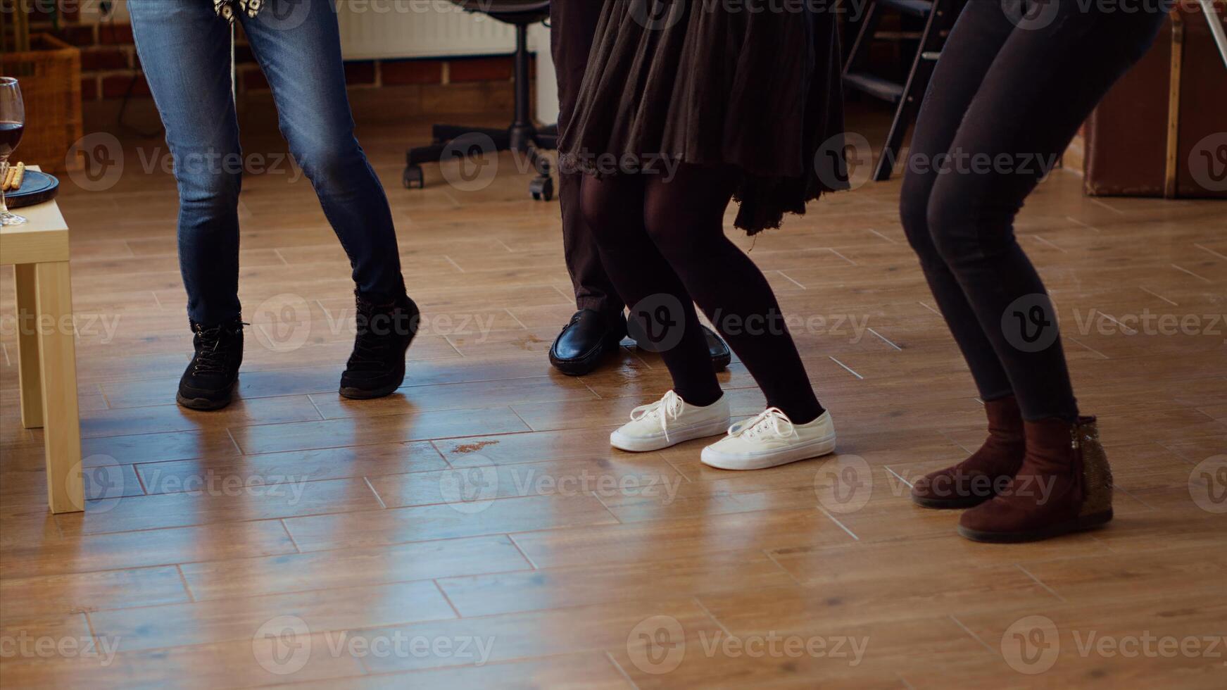 Close up shot of guests feet dancing and spinning around house during entertaining apartment party. People legs moving on energetic music rhythm, doing dance moves at social gathering photo