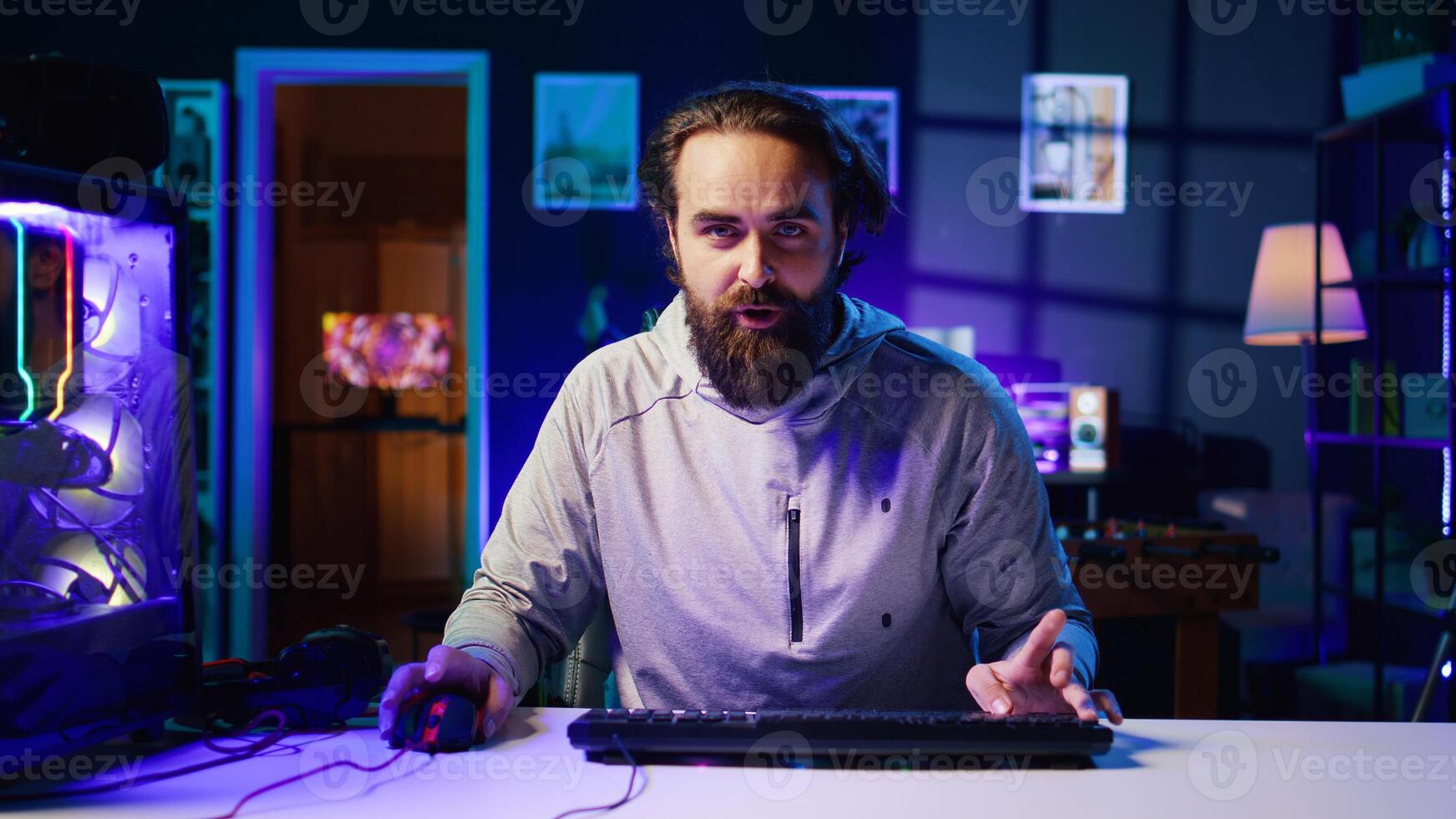 Content creator turning gaming chair around, greeting audience, filming tutorial on how to defeat enemies in multiplayer game. Pro gamer playing videogame, teaching viewers esports strategies photo