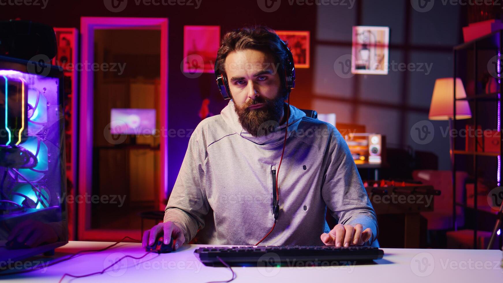 Focused gamer plays intense videogame tournament online during stream with audience, trying to defeat opponent. Player participating in esports competition during livestream, fighting enemies photo