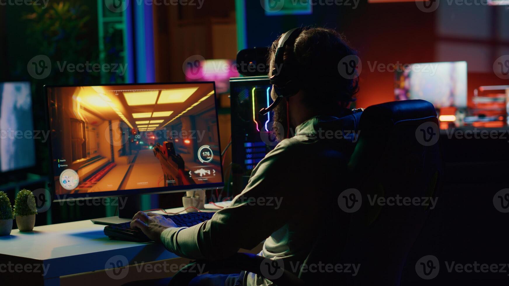 Man putting on headphones to communicate with teammates while playing first person shooter videogame with gun shooting laser bullets. Gamer talking with online friends while enjoying game photo
