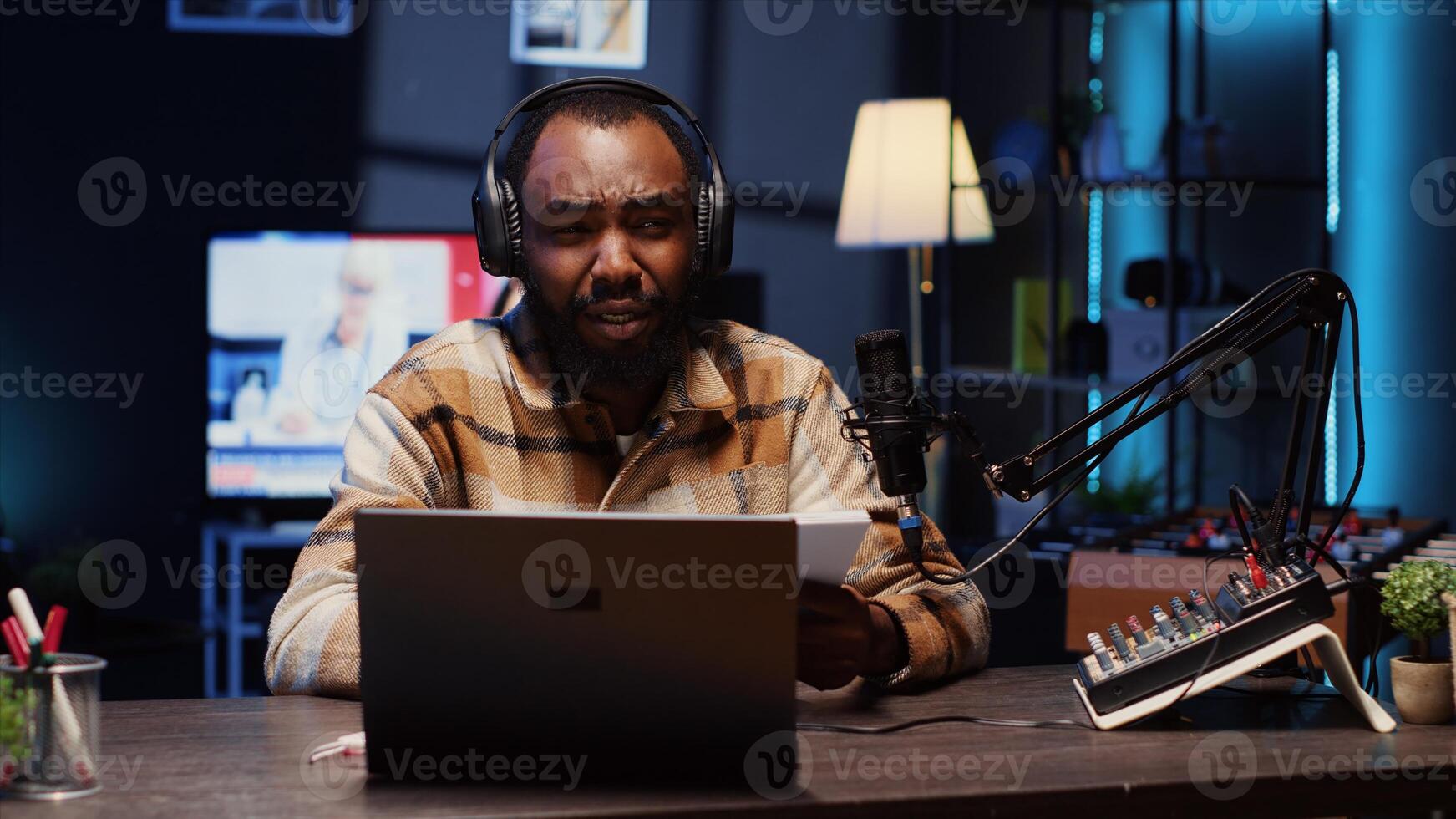 Portrait of BIPOC content creator broadcasting live on streaming platform from vibrant studio using professional tools producing high quality audio. Man creating engaging social media content photo
