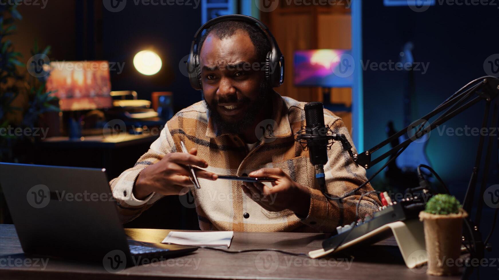 BIPOC tech guru assessing smartphone performance, expressing dissatisfaction with subpar components used. Man shooting mobile phone review for online channel, displeased with low quality materials photo