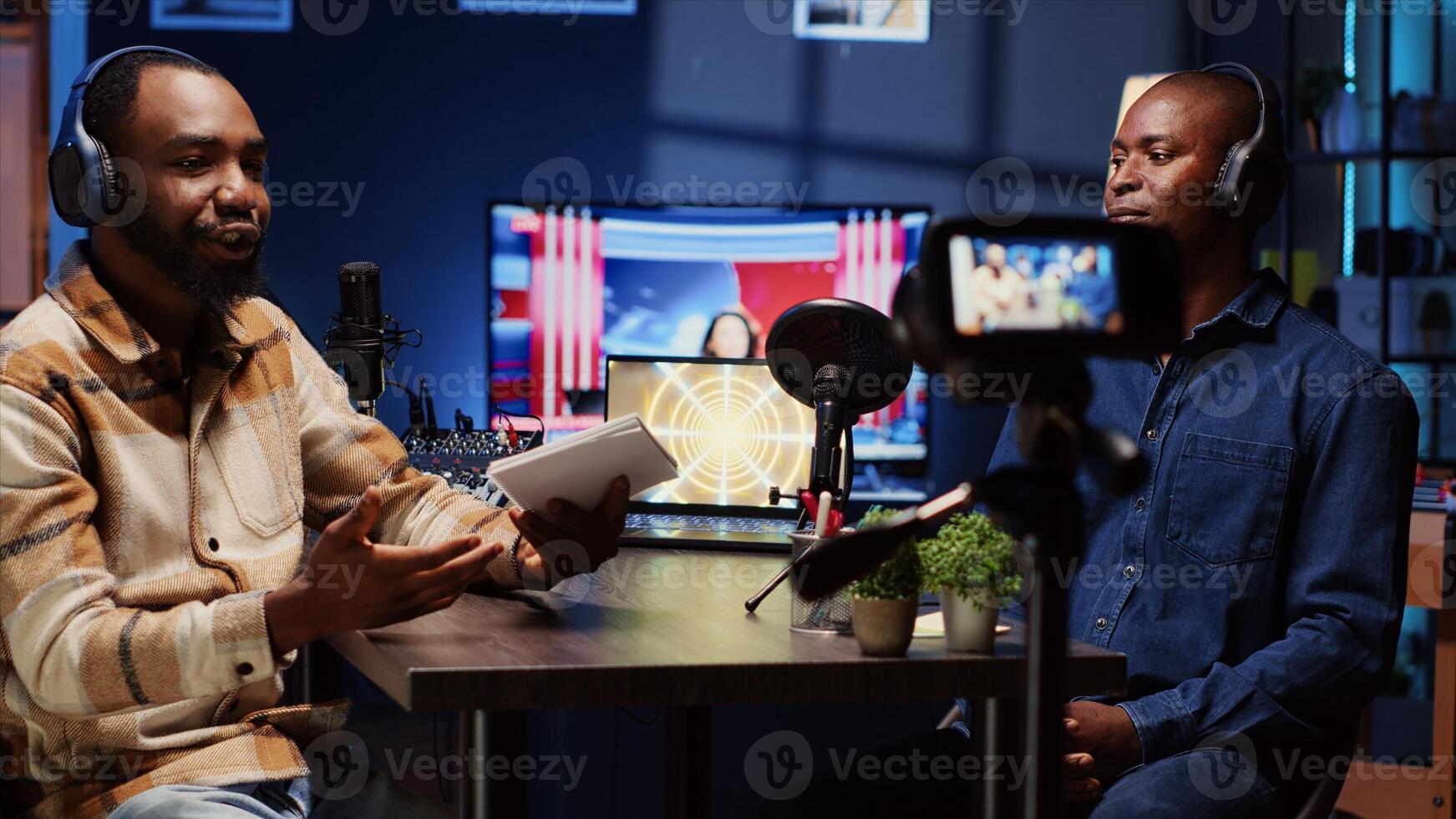 Man on podcast using professional equipment while talking with guest during marathon live broadcast for good humanitarian cause, gathering donations from viewers, filming with camera, panning shot photo