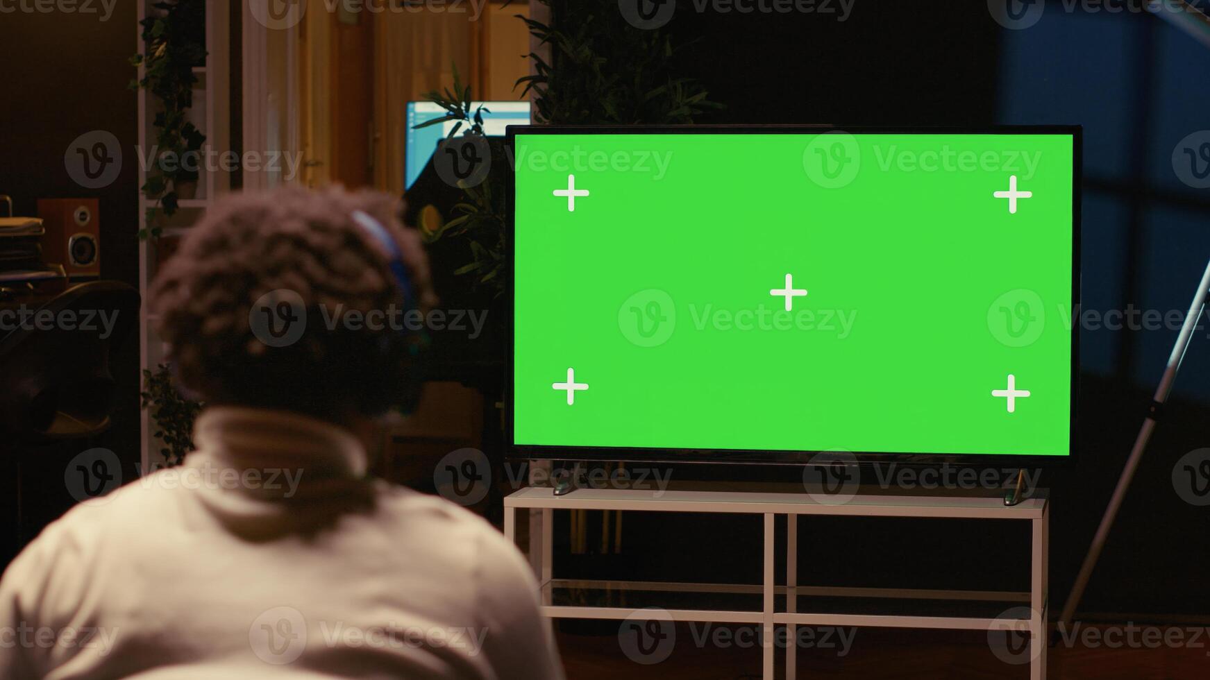 Man playing singleplayer videogames on green screen TV in cozy living room used as home theatre. Gamer using controller to beat game on gaming console attached to mockup television set photo