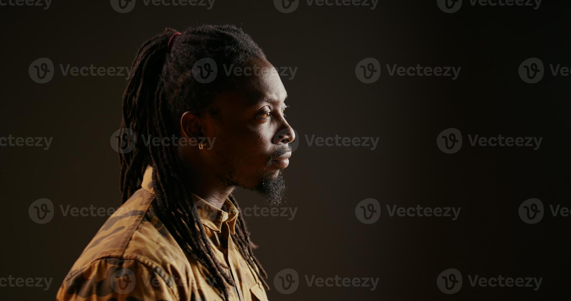 African american person being surprised seeing something in studio, being amazed and admiring view over black background. Male model looking around and feeling shocked, saying wow. photo