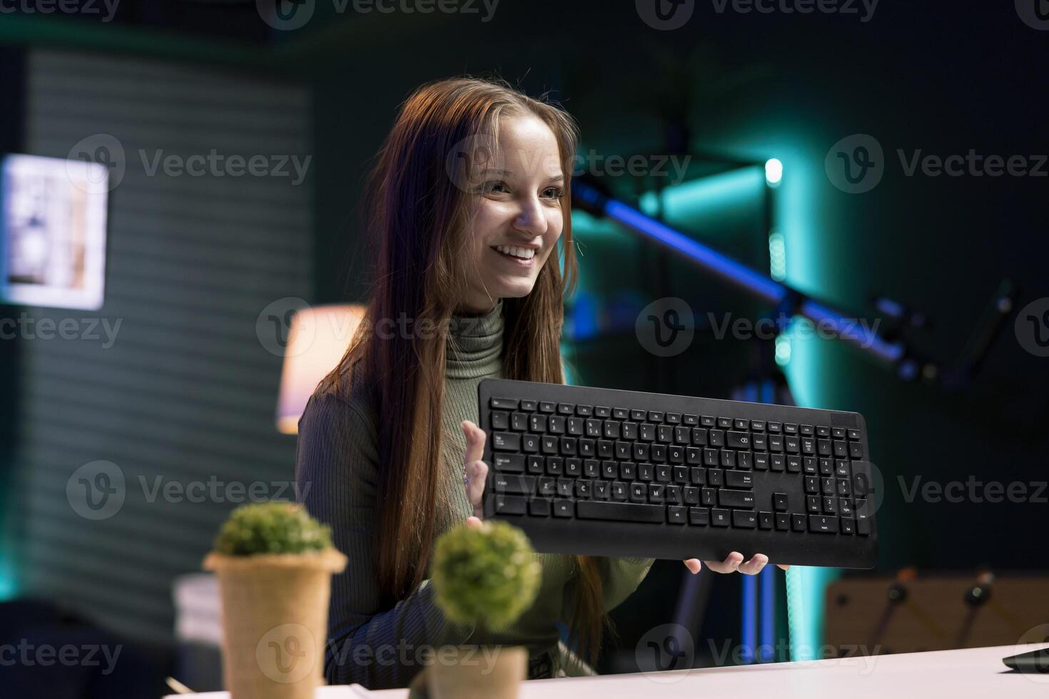 Cheerful content creator analyzing mechanical keyboard received from sponsor, doing honest review for online streaming channel. Internet show host reviewing computer peripherals brand photo