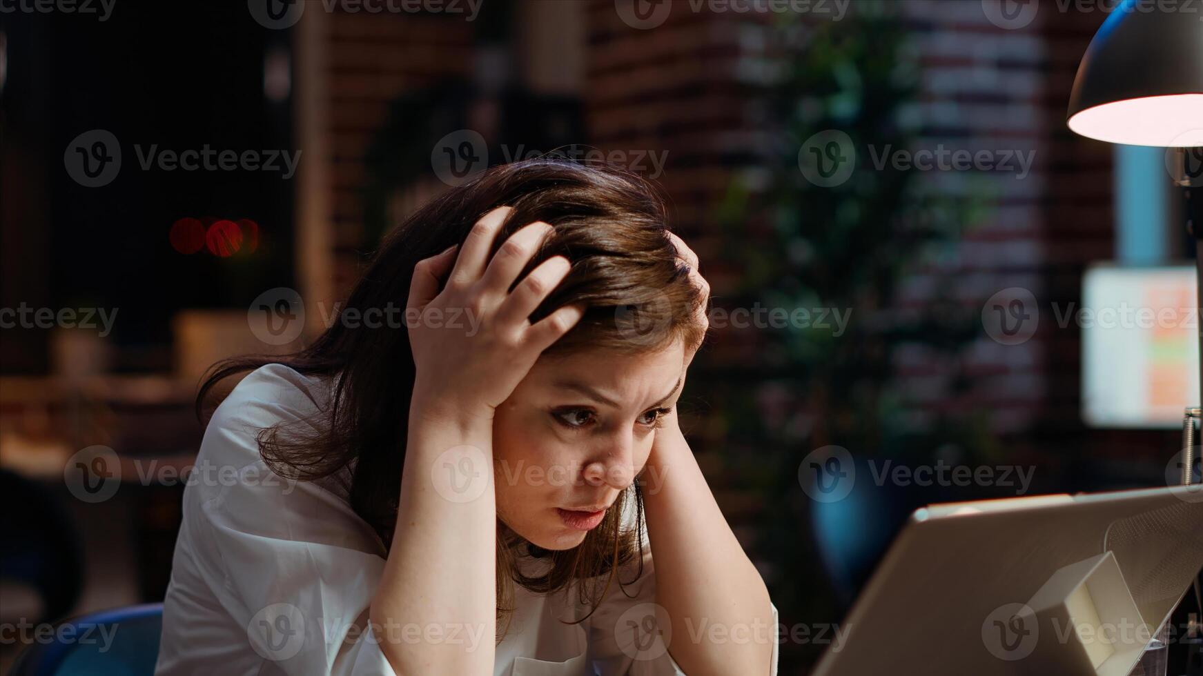 Worker frustrated by mistake she made while inputting data on laptop while working on company project overnight. Close up shot of upset businesswoman realizing error she made photo
