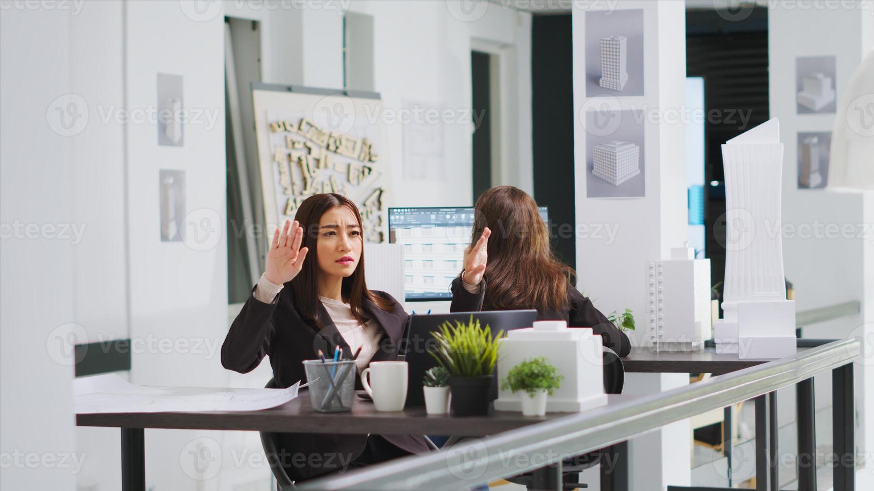 Graphic design consultant who uses holographs to shape layouts, real estate agency. Asian designer establishing reconstruction plan using hologram visuals and artificial intelligence. photo