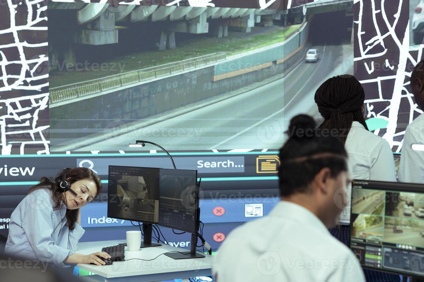 Frustrated employee working under pressure in agency control center, failing to properly monitor delivery trucks in traffic. Operator feels overworked, uses satellite map and gps tracking. photo