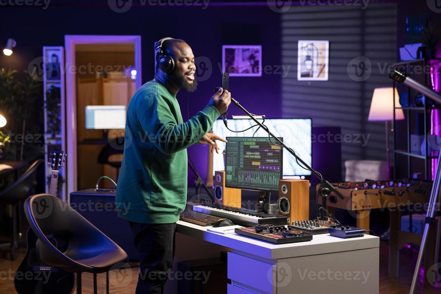 Talented composer artist does a recording session for his acoustic tunes, performing on microphone in home studio. Confident singer working on producing new soundtracks for an album. photo