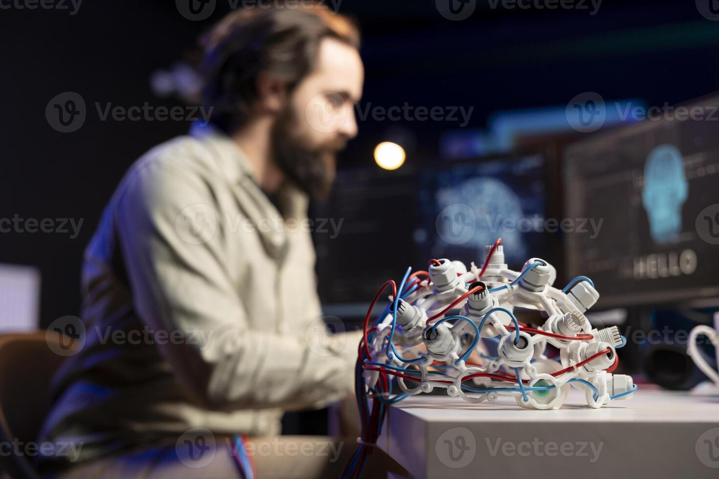 Focus on EEG headset used by engineer in blurry background to upload consciousness into computer. Close up shot of high tech gear used by IT expert to create connection between brain and PC photo