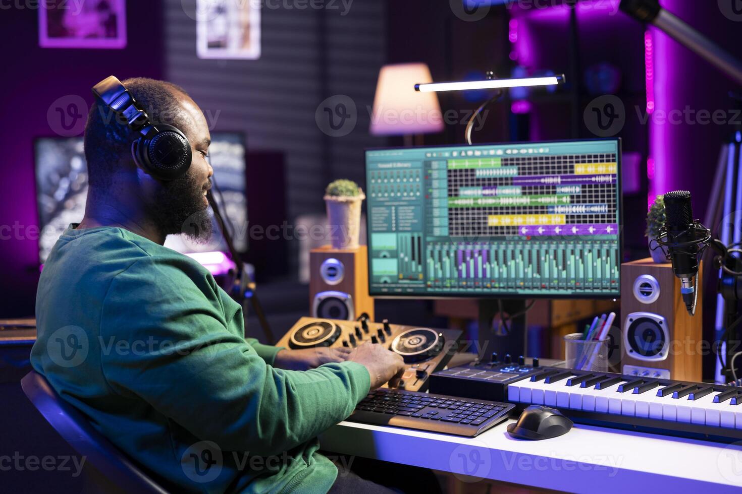 Skilled audio technician mixing and mastering tunes on console, adding sound effects in post production. Songwriter producing new tracks for his album, working in home studio with gear. photo