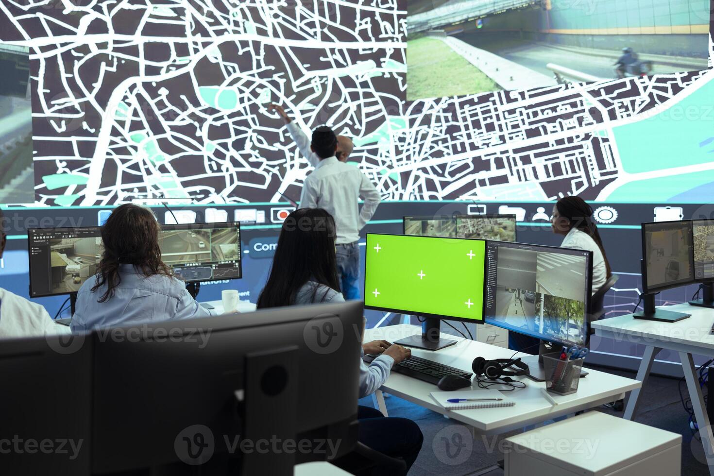 Indian woman dispatcher works with isolated copyspace on screen next to real time surveillance footage, transmitting gps coordinates to the drivers. Employee uses satellite navigation. photo