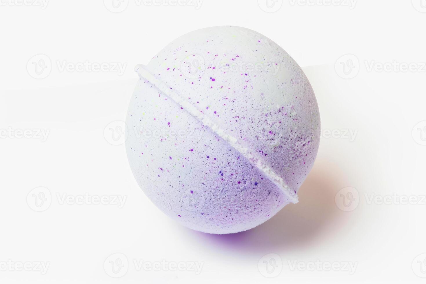 Fresh purple bath bomb presented on a pure white background. Simple and elegant spa accessory. Concept of cleanliness, self-care, tranquil spa experiences, wellness photo