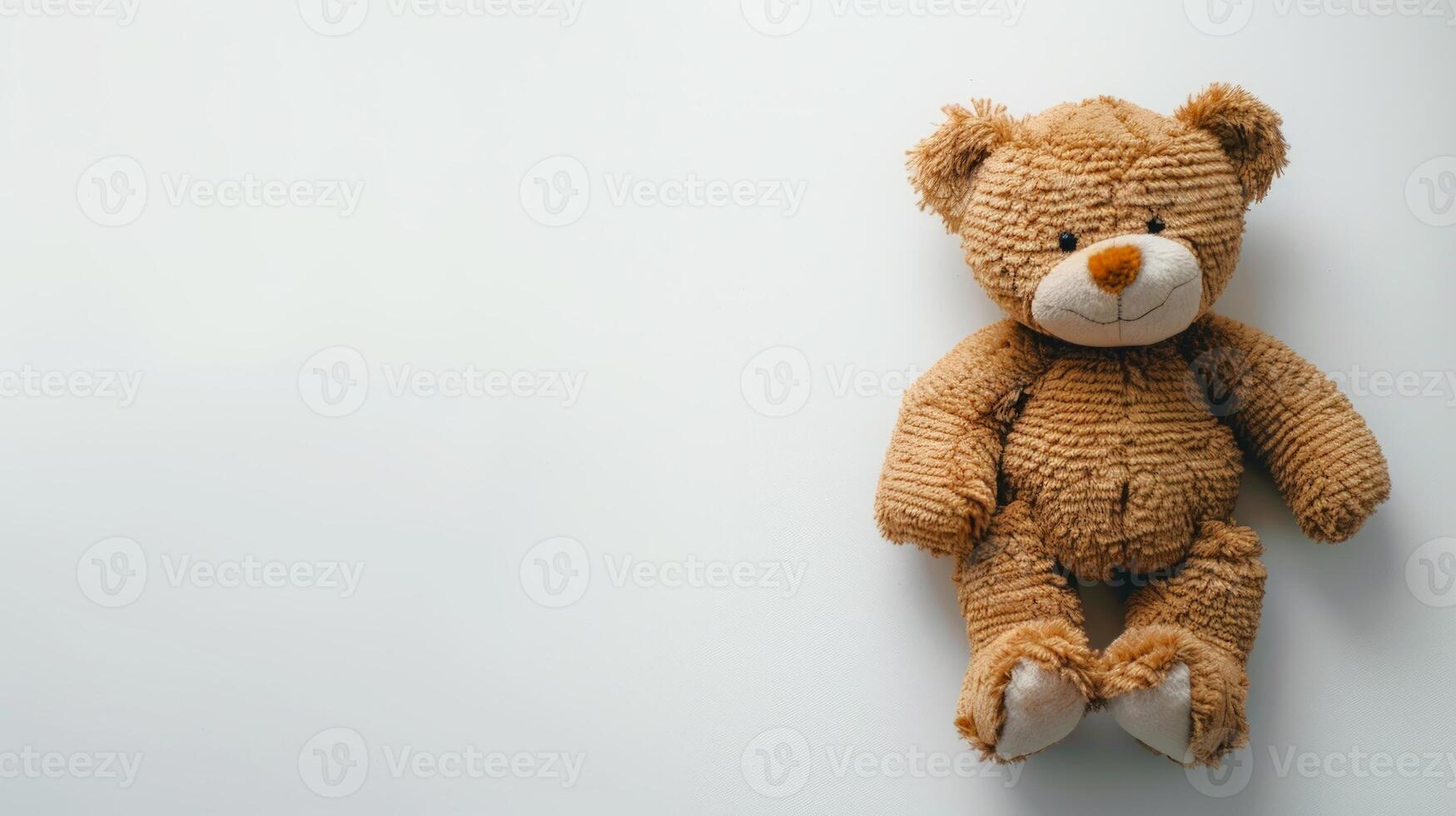 Plush brown toy bear sitting against a white background. Childhood companion. Concept of childhood, comfort, nostalgia, innocence. Copy space photo