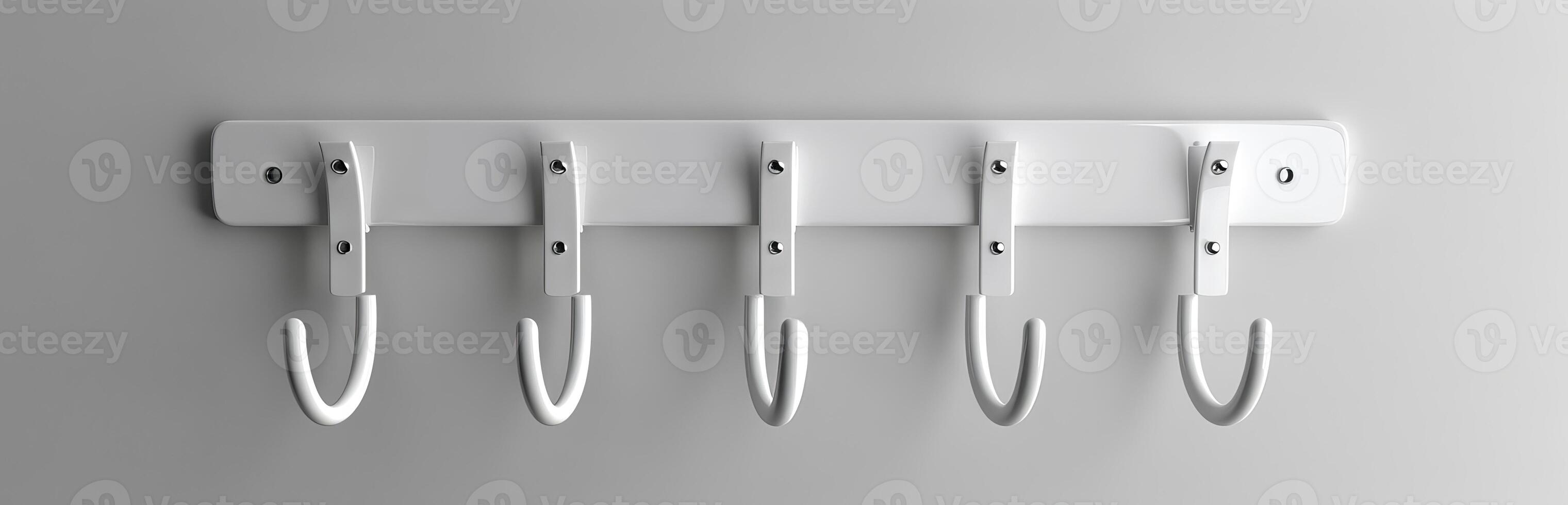 White modern coat rack with five hooks mounted on a wall. Minimalist home organization concept. Concept of interior design, home storage, simplicity, functionality photo