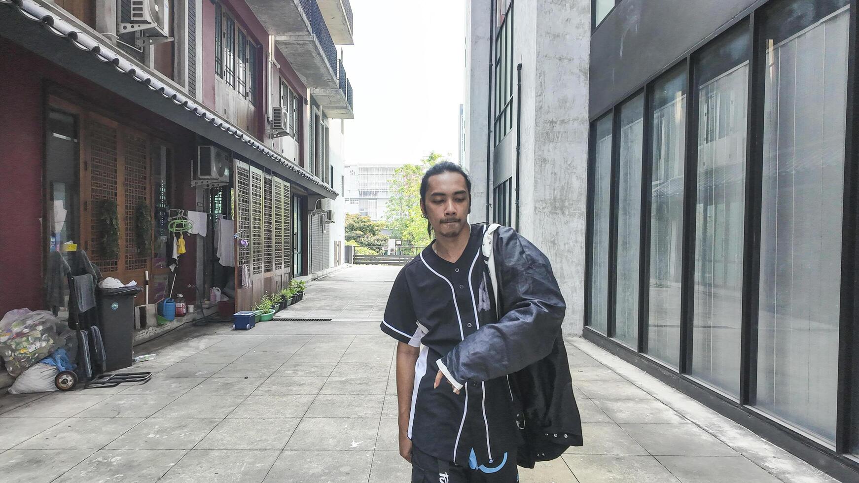 ASian man is dancing in hip hop style at outdoor space. Professional solo dancer is performing in public area. photo