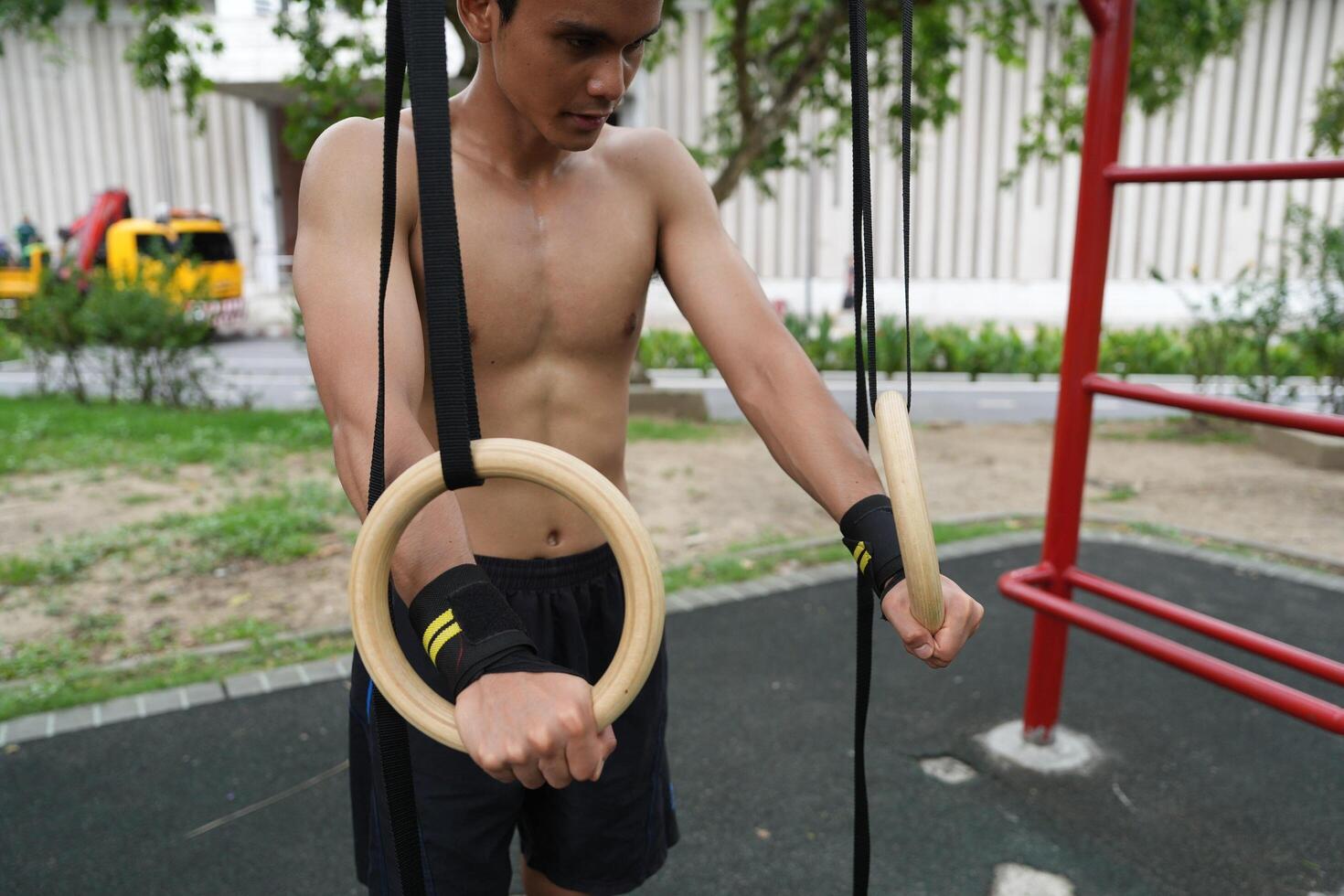 Asian man practicing gymnastics, doing gymnastics bar and hoop exercises and stretching, resting for sports. photo
