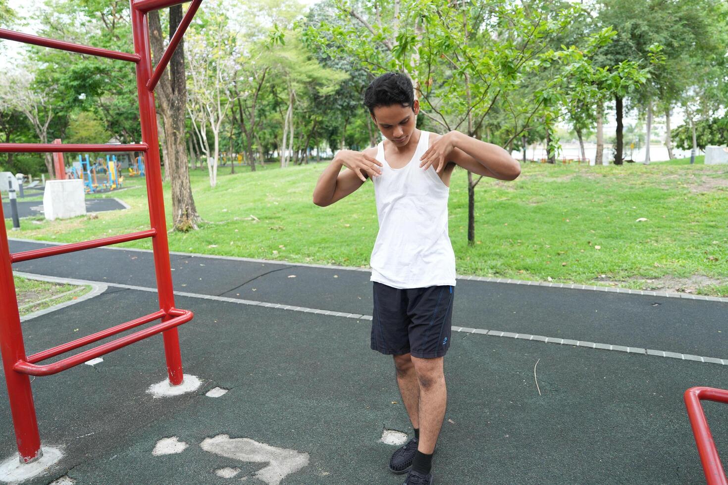 Asian man practicing gymnastics doing gymnastics bar and hoop exercises and stretching and resting for sports. photo