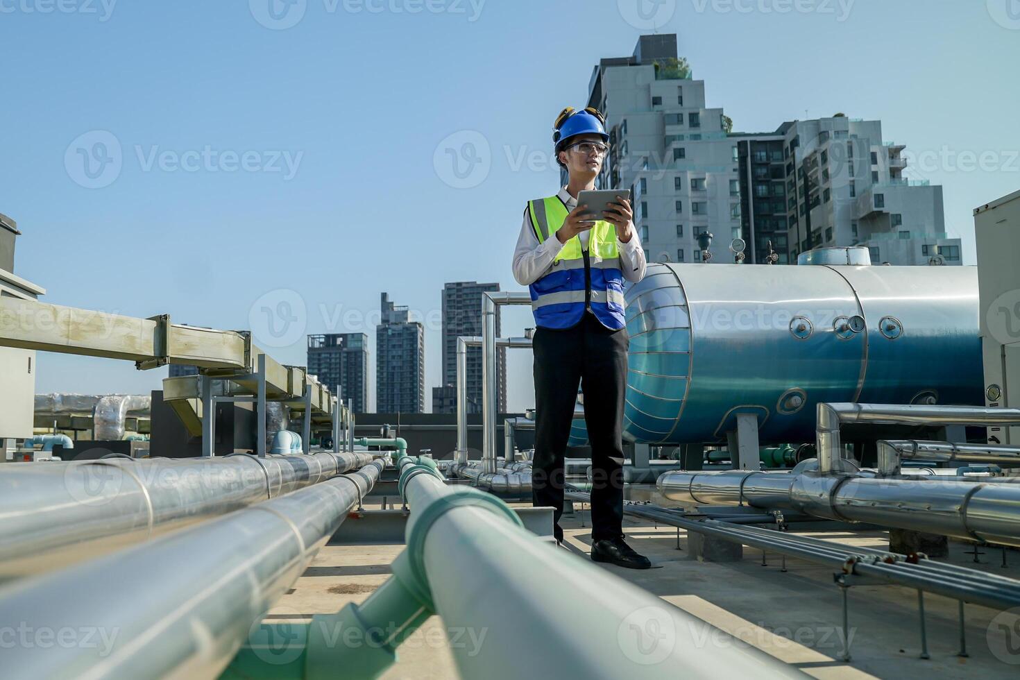 Urban rooftop scene showing a young engineer with a radio, inspecting and adjusting equipment in a sunny city environment. Safety and precision at work. photo