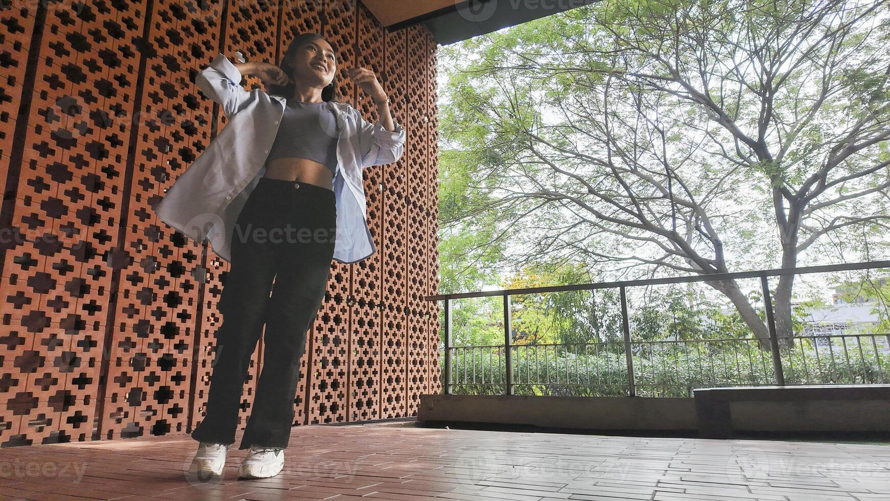 Asian girl dances freestyle hip-hop in an open space. photo