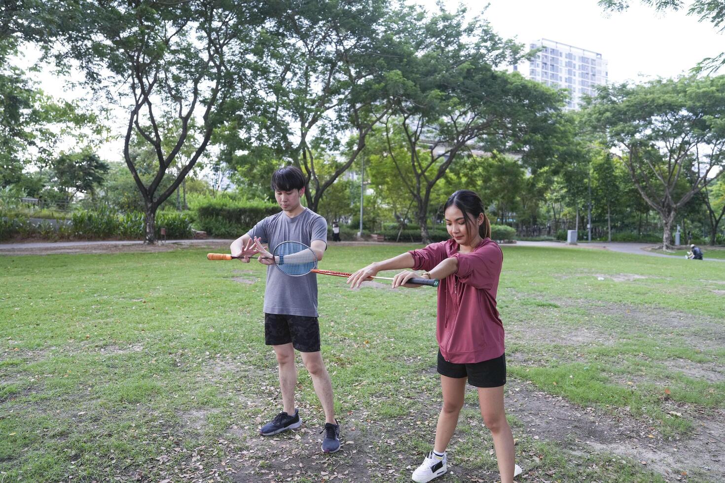 Young people play badminton and repair diligently in the park area. photo