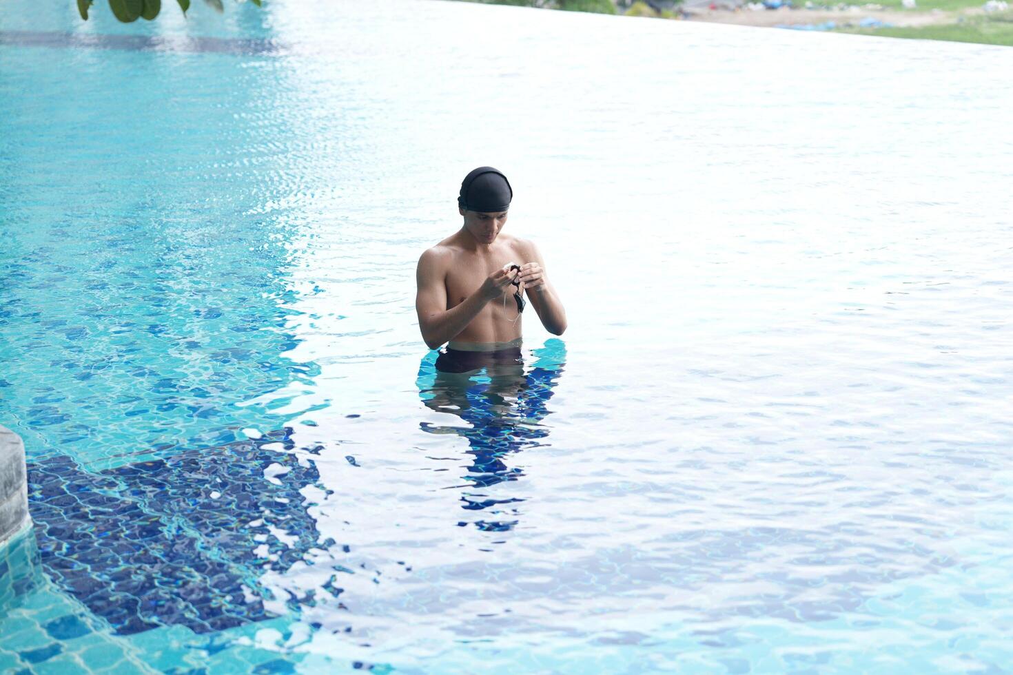 Asian men practicing swimming and preparing to play water polo and stretching and resting for water sports. photo