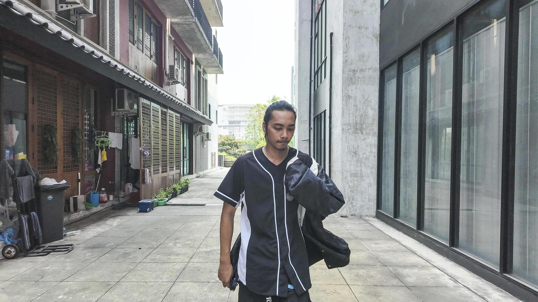 ASian man is dancing in hip hop style at outdoor space. Professional solo dancer is performing in public area. photo