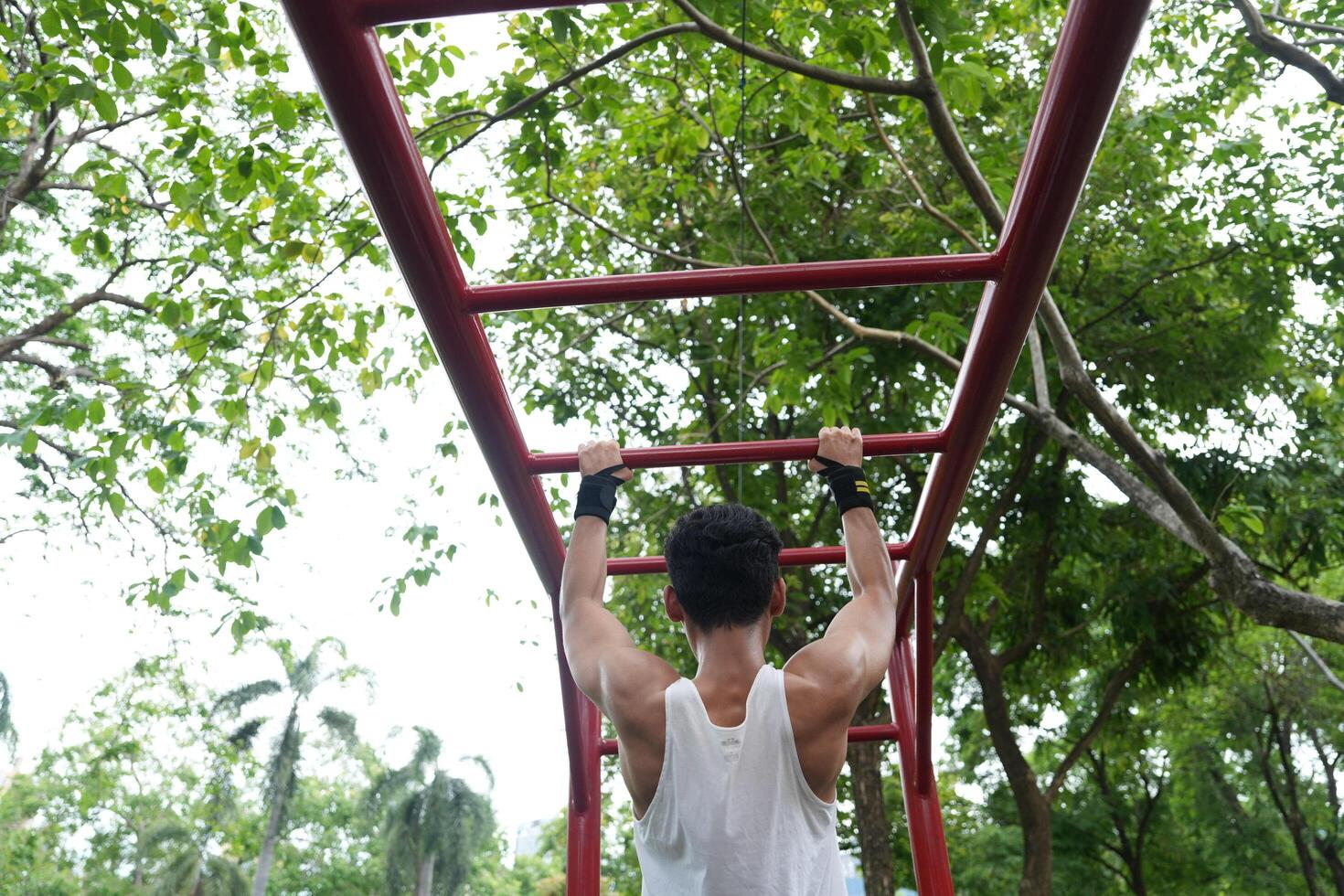 Asian man practicing gymnastics, doing gymnastics bar and hoop exercises and stretching, resting for sports. photo