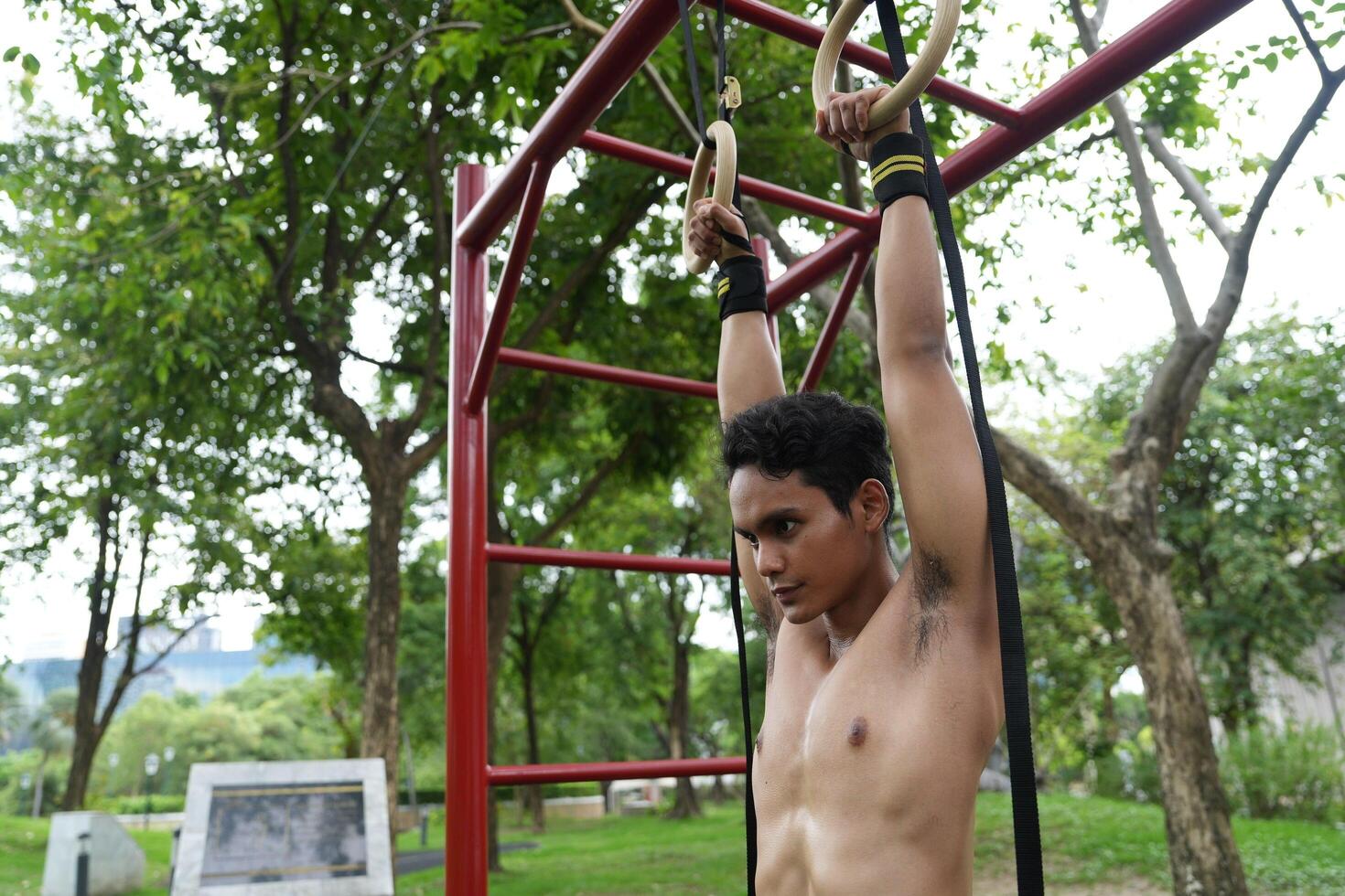 Asian man practicing gymnastics, doing gymnastics bar and hoop exercises and stretching, resting for sports. photo