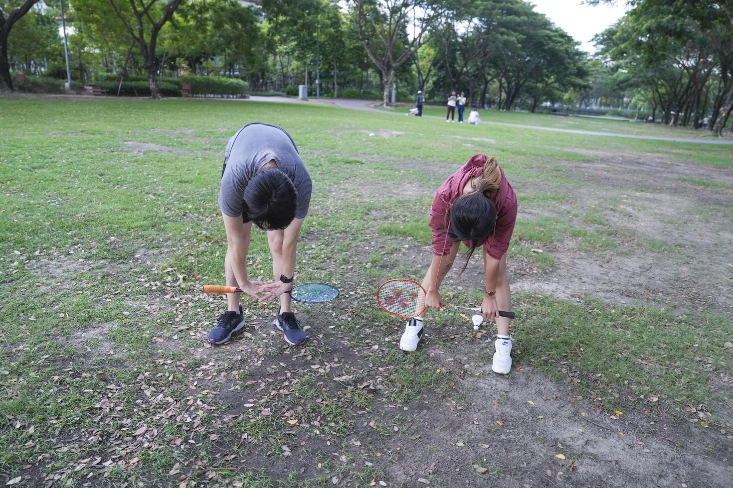 Young people play badminton and repair diligently in the park area. photo