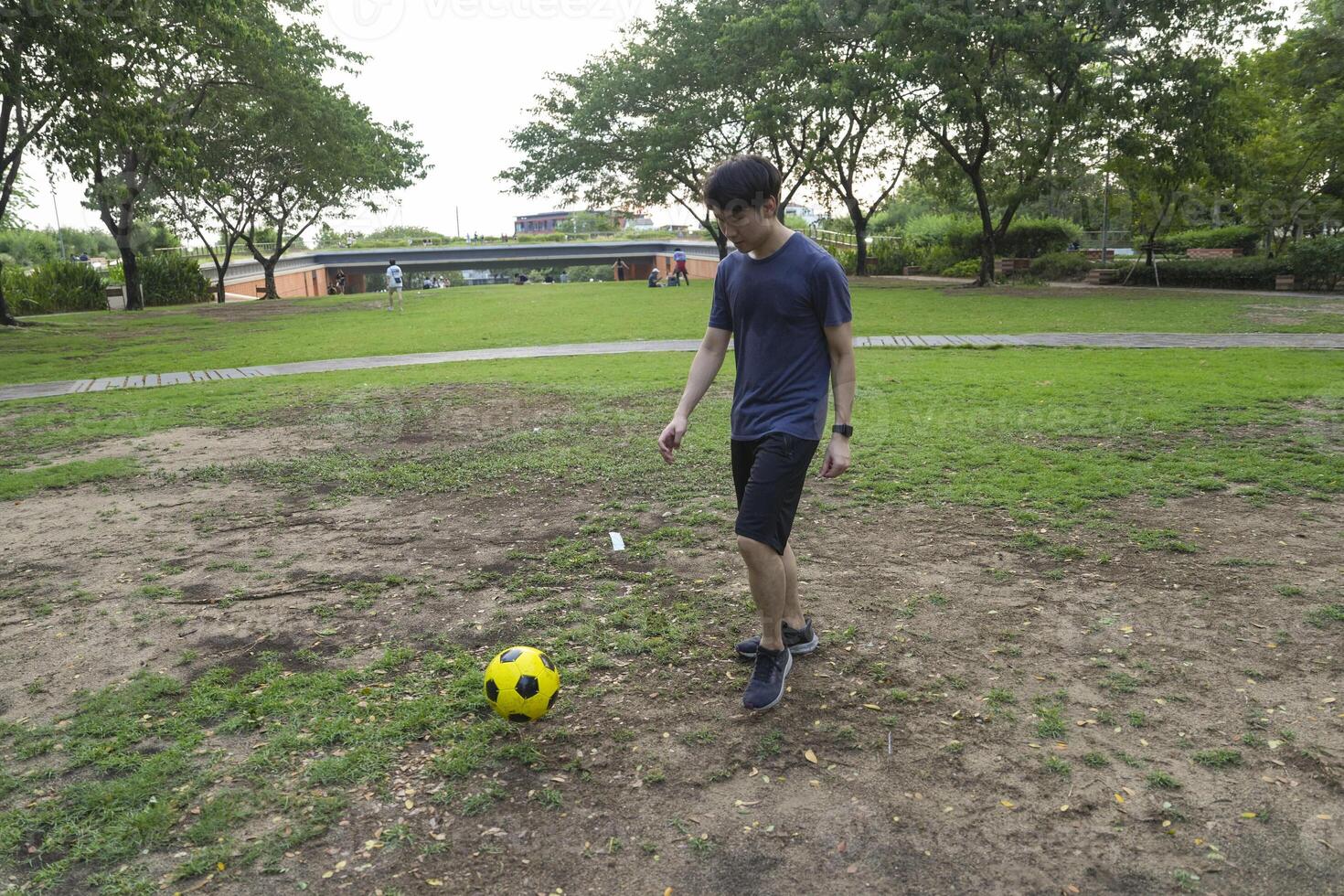 Male soccer players practice using the ball in the park field diligently and happily. photo