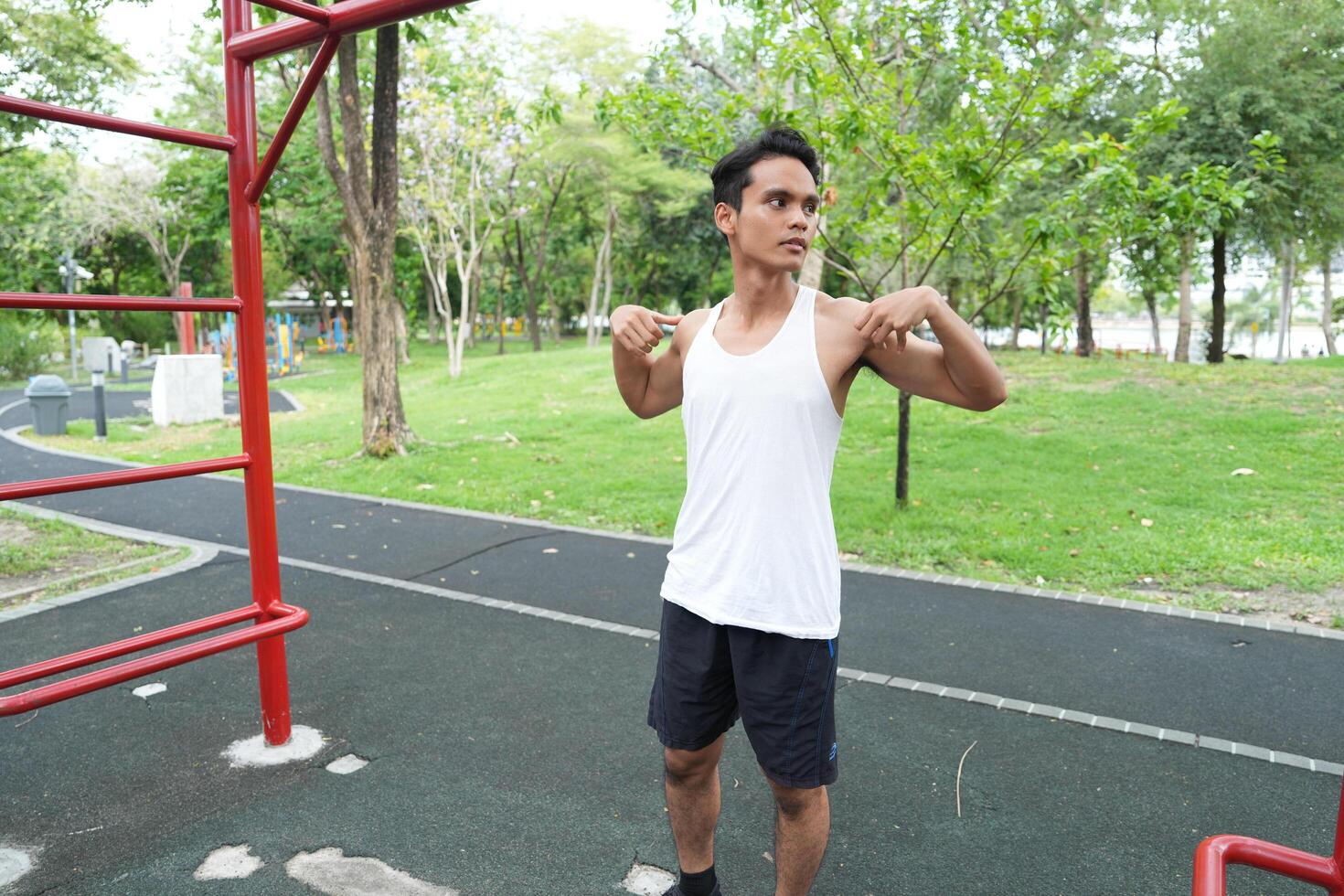 Asian man practicing gymnastics doing gymnastics bar and hoop exercises and stretching and resting for sports. photo