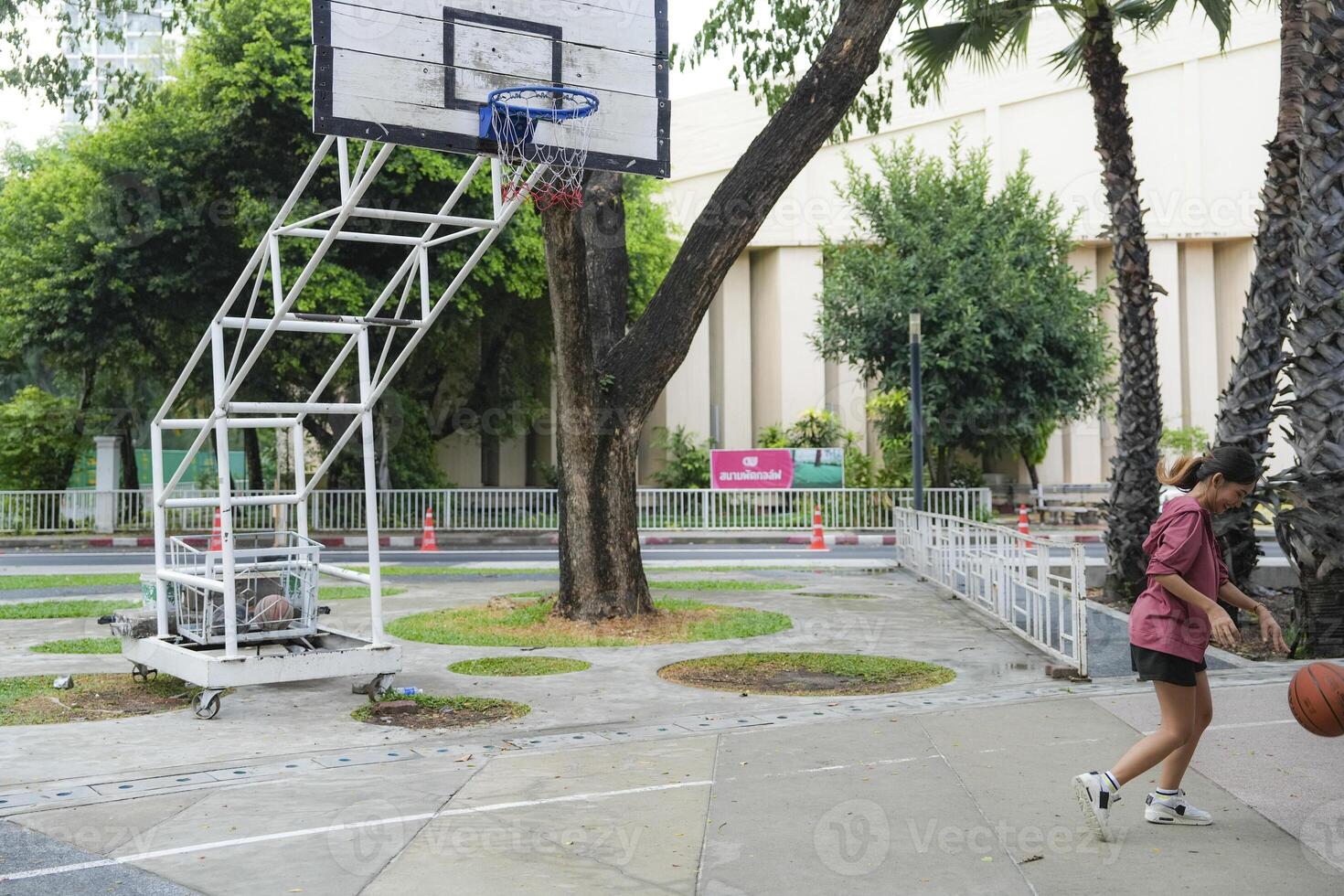 The male and female basketball players practice using the ball in the park court diligently and happily. photo