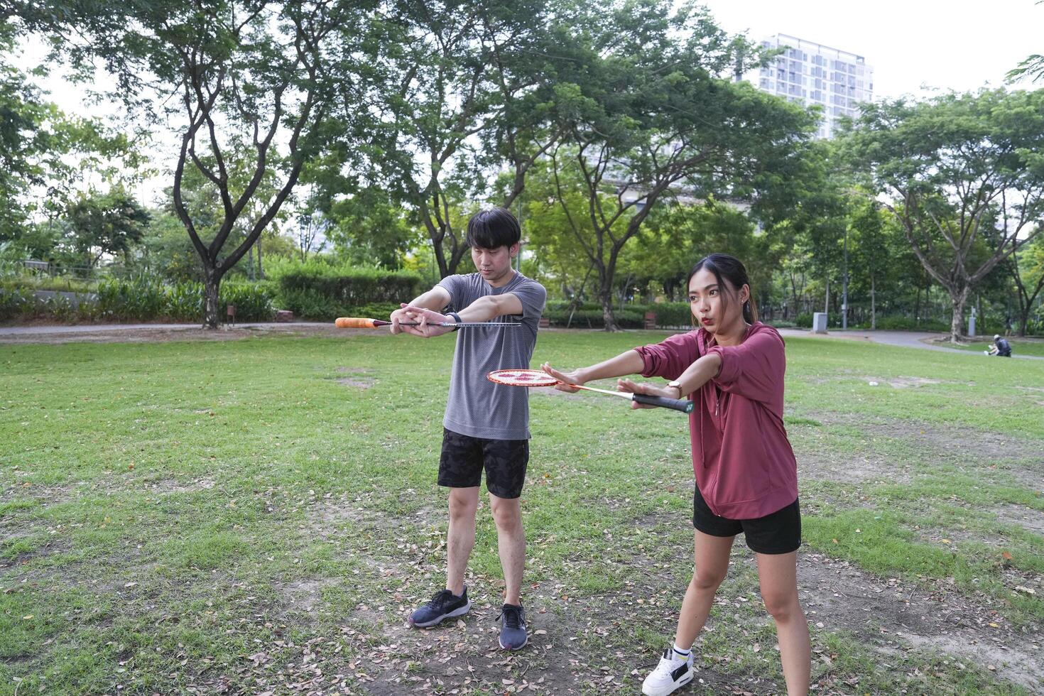 Young people play badminton and repair diligently in the park area. photo