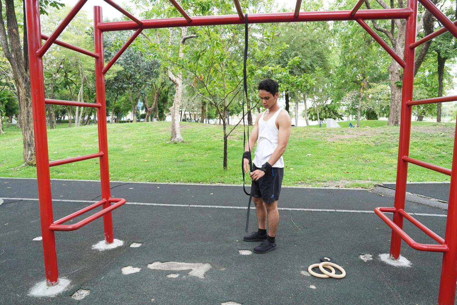 Asian man practicing gymnastics doing gymnastics bar and hoop exercises and stretching and resting for sports. photo