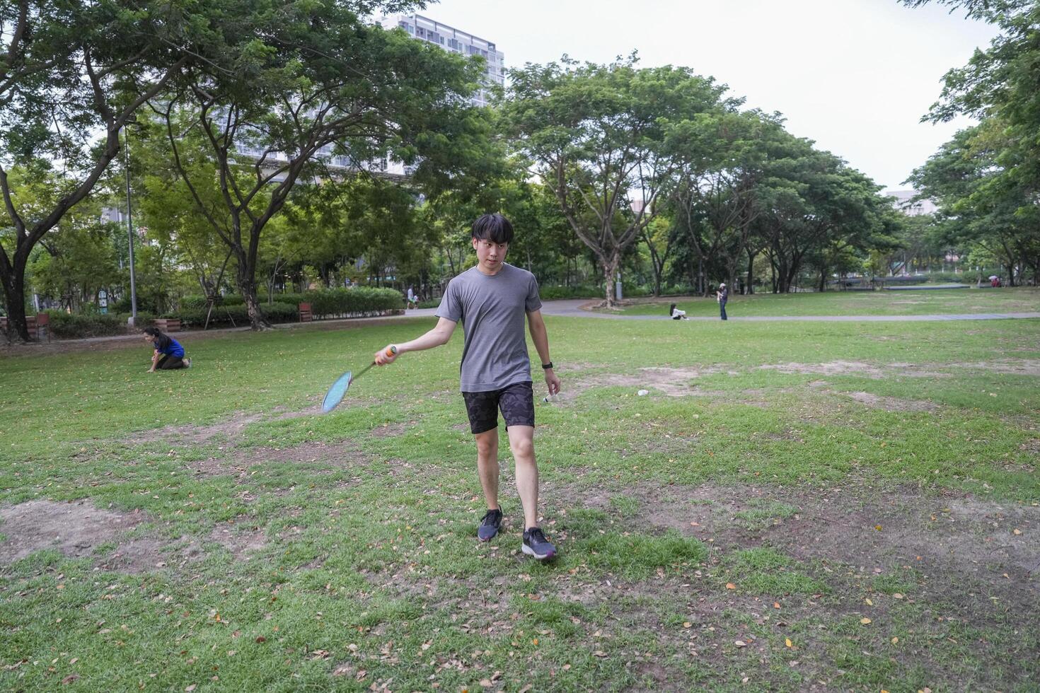 Young people play badminton and repair diligently in the park area. photo