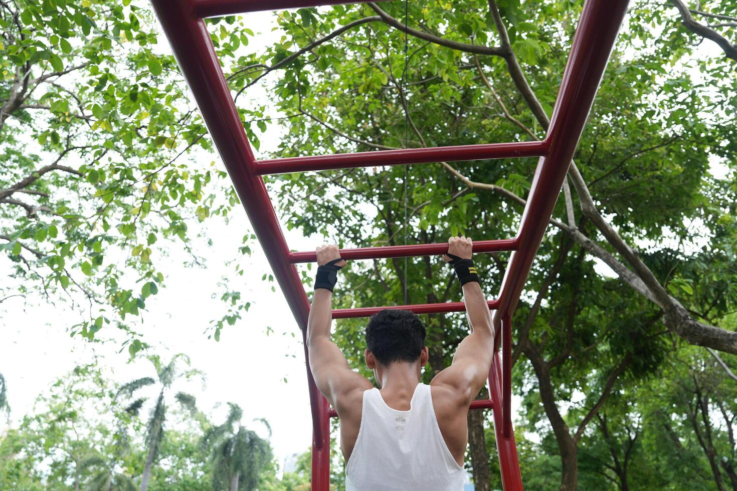 Asian man practicing gymnastics, doing gymnastics bar and hoop exercises and stretching, resting for sports. photo