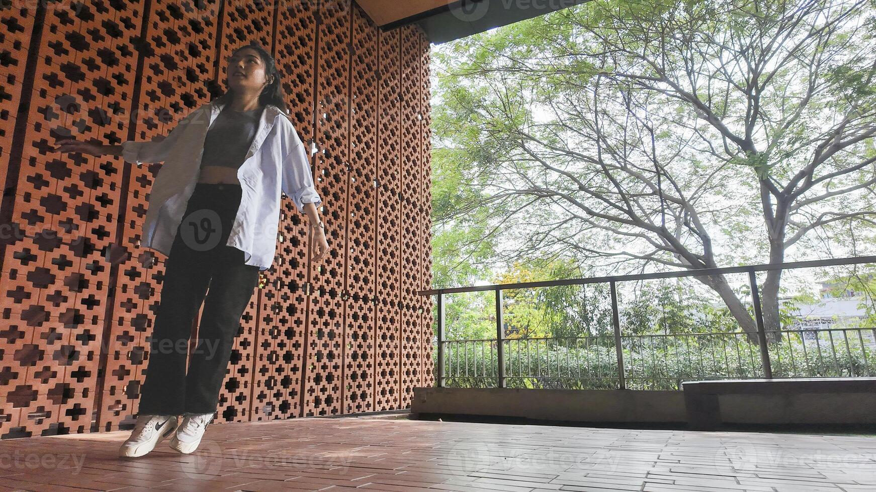 Asian girl dances freestyle hip-hop in an open space. photo