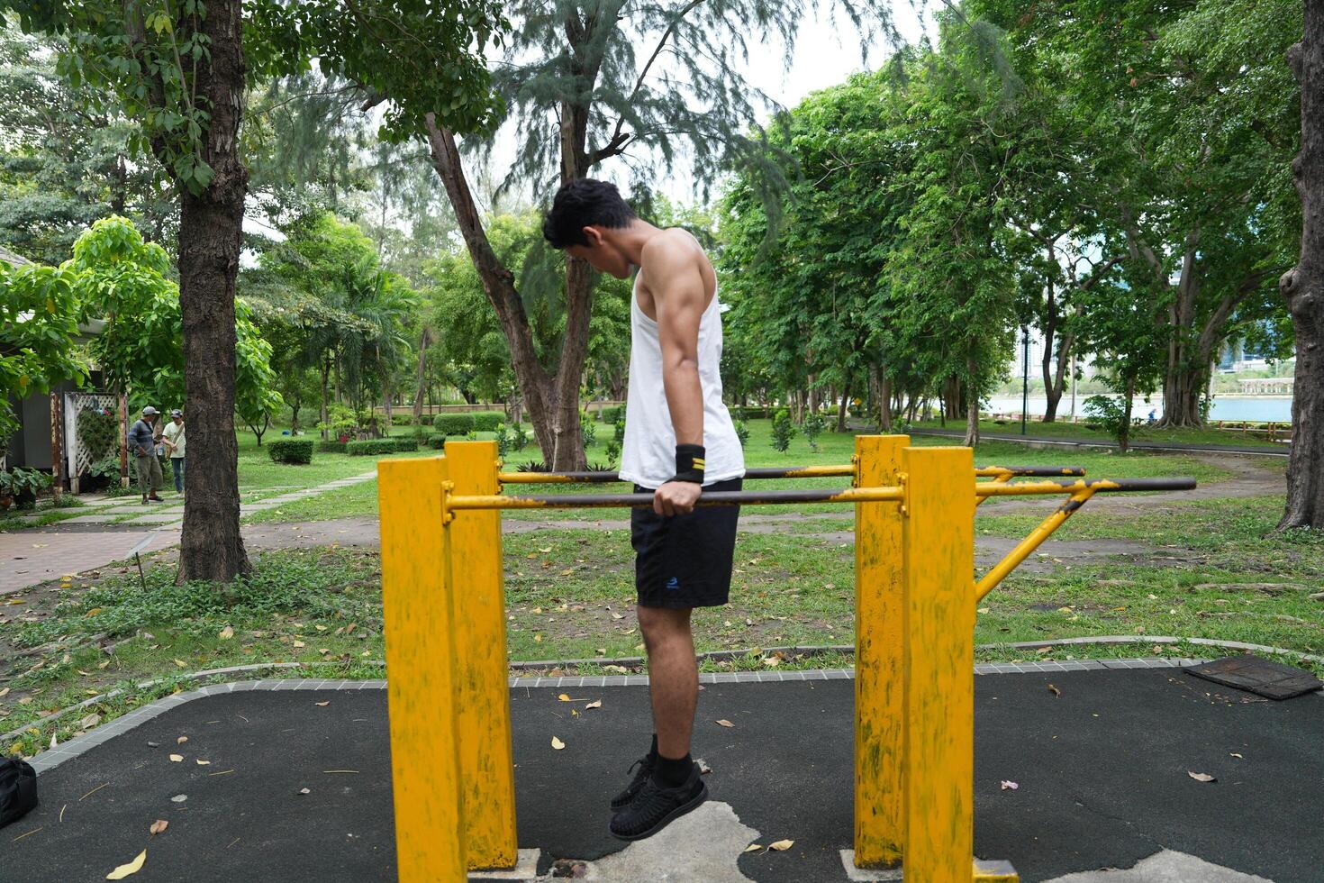 Asian man practicing gymnastics, doing gymnastics bar and hoop exercises and stretching, resting for sports. photo
