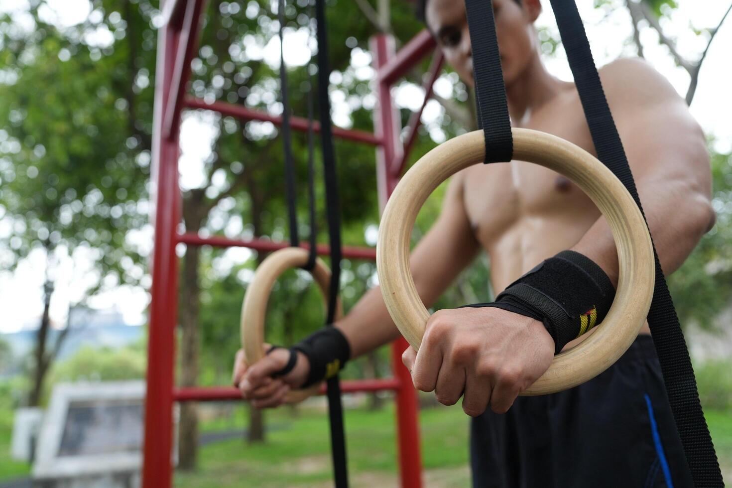 Asian man practicing gymnastics, doing gymnastics bar and hoop exercises and stretching, resting for sports. photo