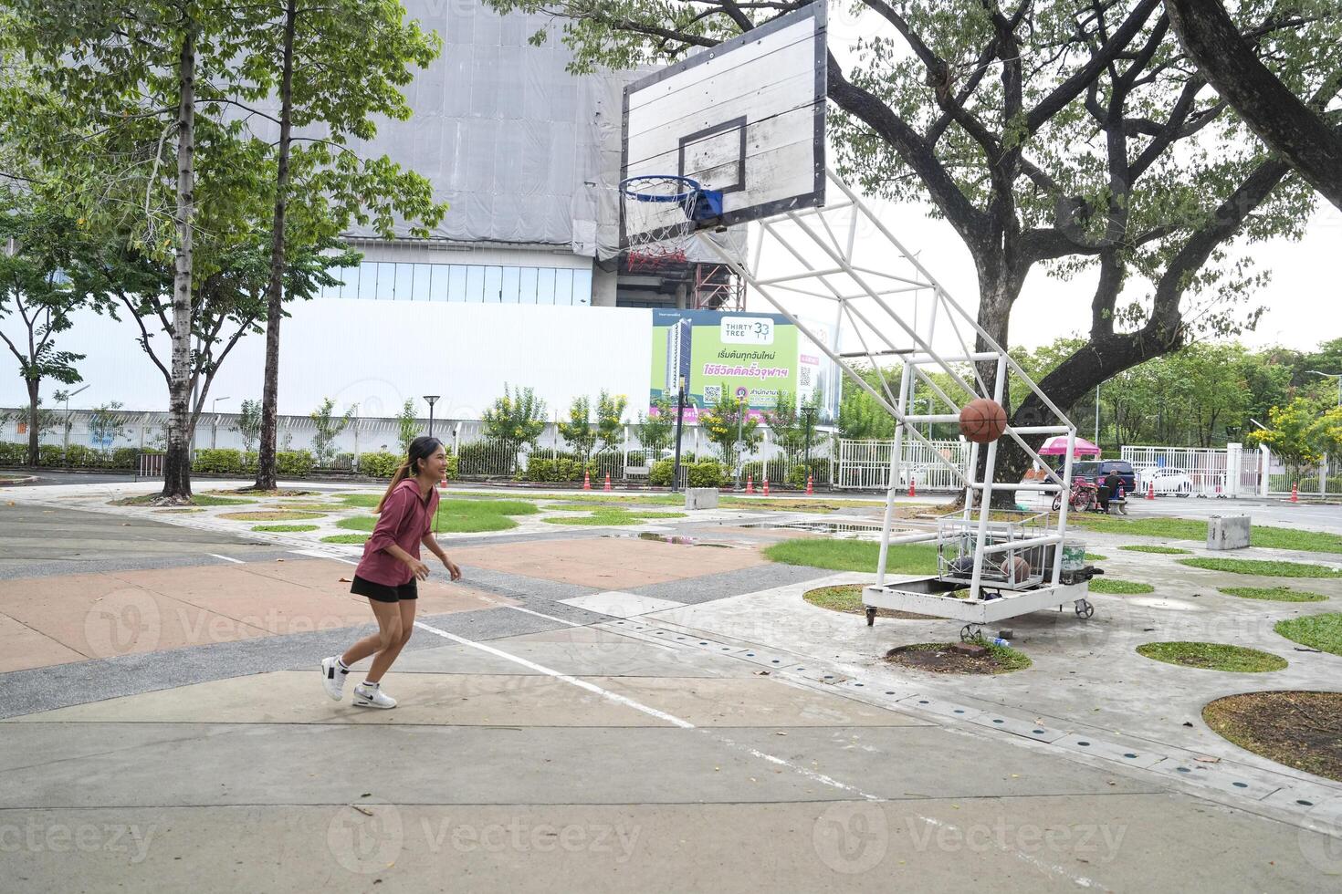 The male and female basketball players practice using the ball in the park court diligently and happily. photo