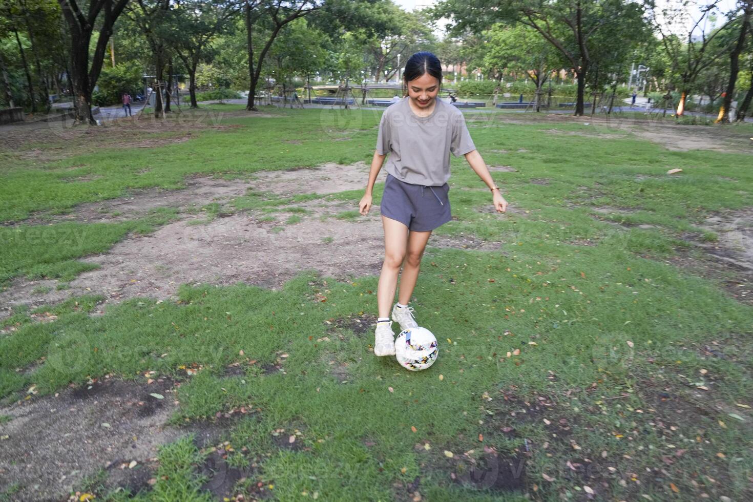 hembra fútbol jugadores práctica utilizando el pelota en el parque campo diligentemente y felizmente. foto