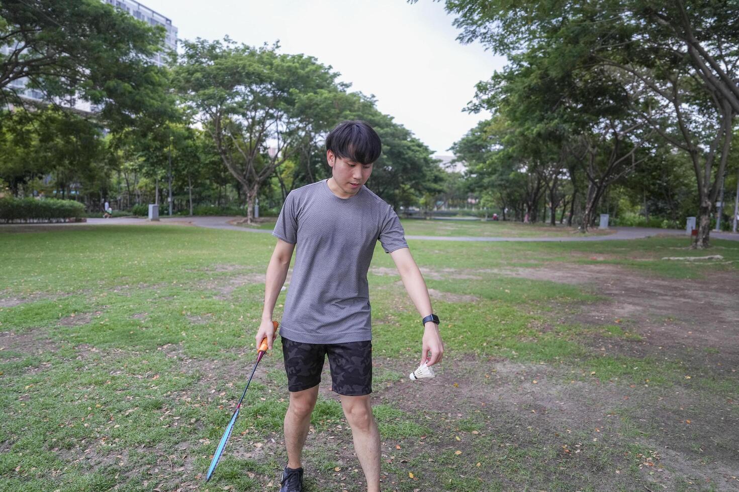 Young people play badminton and repair diligently in the park area. photo