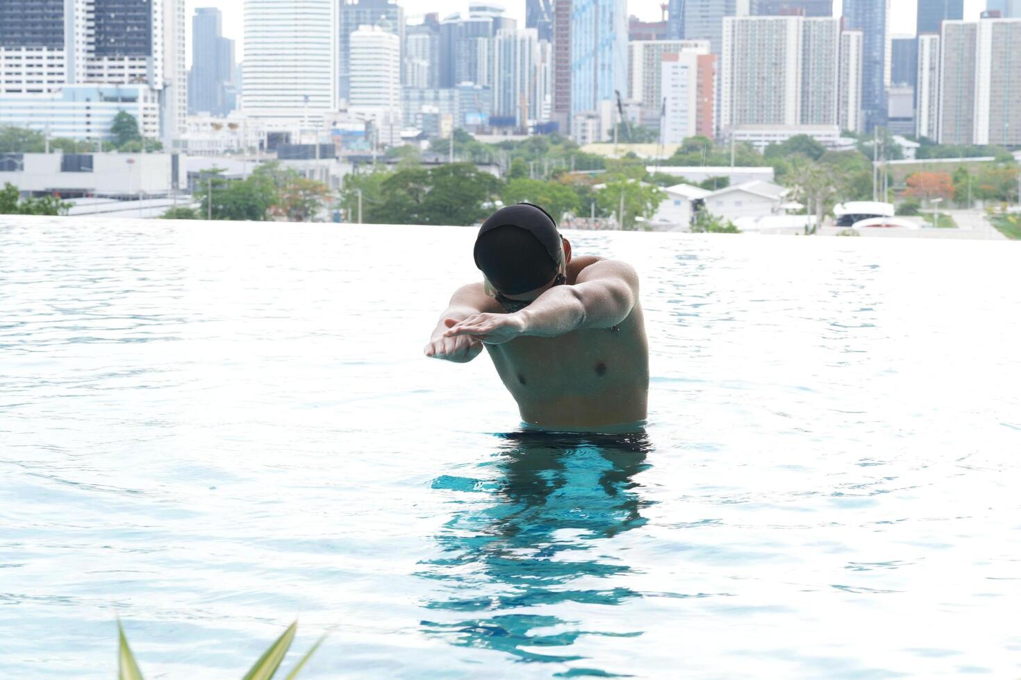 Asian men practicing swimming and preparing to play water polo and stretching and resting for water sports. photo